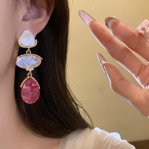 Vue détaillée de boucles d'oreilles pendantes en résine vintage de style cour élégant.