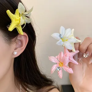 Close-up of starfish and flower hair clips with decorative water drops for summer.