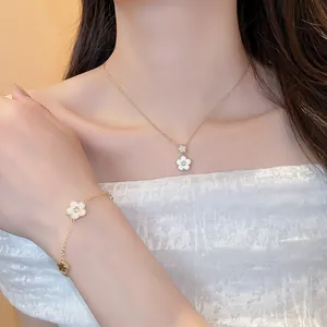 Detailed view of gold-plated zircon flower necklace and bracelet set on an Asian model