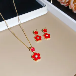Gold-plated jewelry set featuring red enamel flower necklace and matching stud earrings.