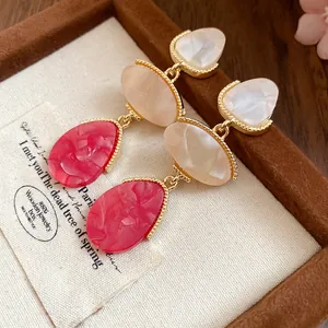 Vue détaillée des boucles d'oreilles vintage en résine marbrée rouge et crème