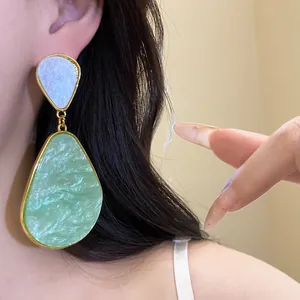 Close-up detail showing green marble resin water drop earrings with vintage golden trim.
