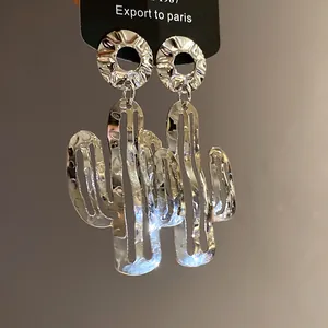 Detailansicht der silbernen Metallkaktus-Ohrringe mit gehämmerter Faltenstruktur.