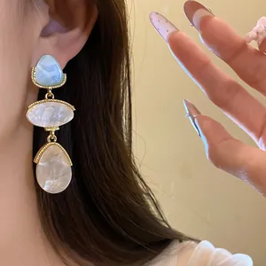 Gros plan de boucles d'oreilles vintage en résine avec bordure dorée style palais.