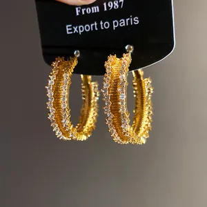 Detailed close-up view of elegant gold plated hoop earrings with sparkling cubic zirconia stones
