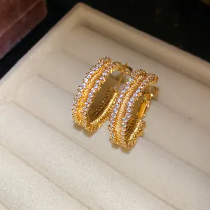 Close-up of gold-plated hoop earrings with sparkling cubic zirconia in a jewelry box