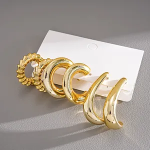 Detailed macro view of a six-piece set of golden C-shaped hoop earrings on display card
