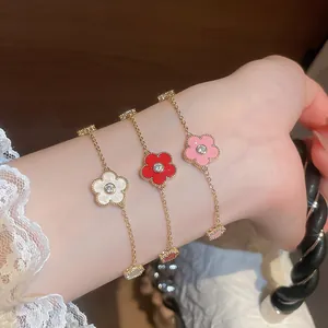 Close-up of three gold-plated zircon flower bracelets in white, red, and pink
