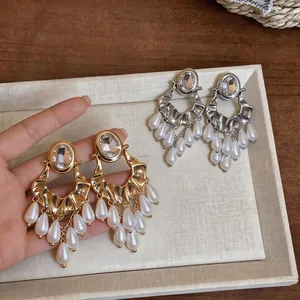 Statement drop earrings featuring oval rhinestones and white pearl tassels in two tones.