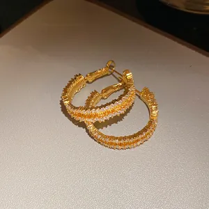 Detailed macro view of 18K gold plated hoop earrings with shimmering micro-paved zirconia