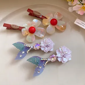 Dettaglio di fermagli per capelli a forma di fiore colorato e coda di sirena