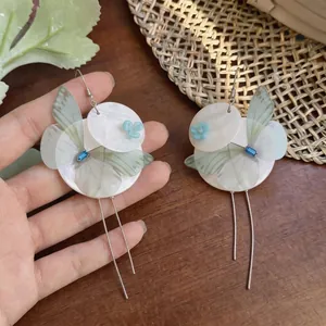 Elegant butterfly shell earrings with long silver tassels and blue floral detail