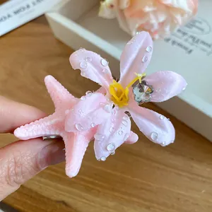 Detail of pink starfish and flower hair clip with realistic water drop beads