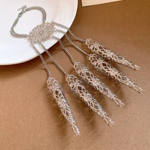 Detailed view of silver hollow-patterned hand chain with five tapered finger claws.