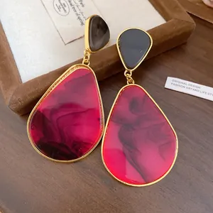 Detail view of vintage resin teardrop earrings with red and black marbled texture finish