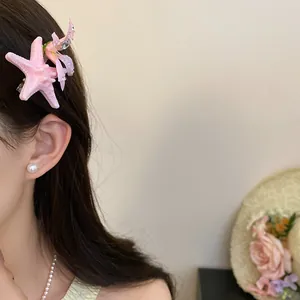 Close-up detail of a pink starfish hair clip with floral accents on a model's hair