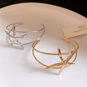 Detailed view of gold and silver metallic starfish open cuff bracelets