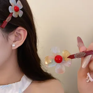 Dettaglio di un elegante fermaglio per capelli a fiore in acetato multicolore.