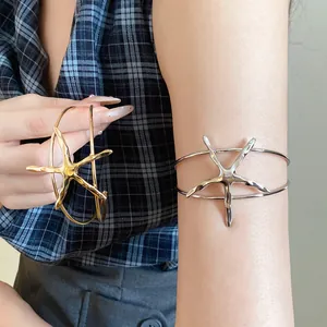 Detail of vintage metal starfish open cuff bracelets in gold and silver finish