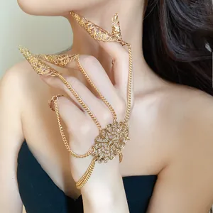 Detail shot of a gold hollow filigree finger claw hand bracelet on an Asian model.
