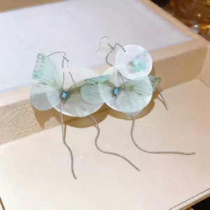 Detailed view of chiffon butterfly shell earrings with long silver tassels
