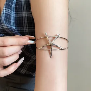 Detailed shot of a silver metal starfish armlet worn on a model's arm