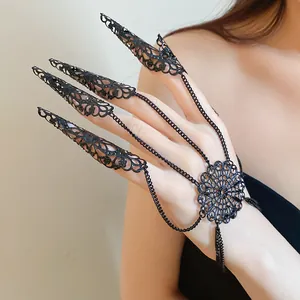 Macro detail of gothic black filigree claw rings connected by intricate chains on a hand