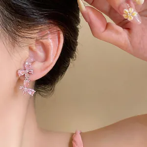 Detailansicht von eleganten rosa Zirkon-Schmetterlings-Ohrringen, die am Ohr getragen werden