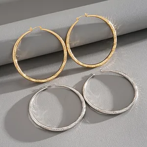 Elegant textured gold and silver hoop earrings with faceted geometric design for women.