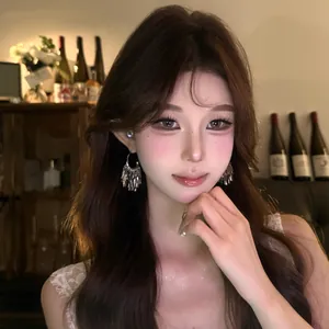 Elegant silver tassel pendant earrings worn by a model in a glamorous night setting