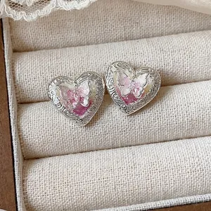 Eleganti orecchini a lobo a forma di cuore con motivo a farfalla e dettagli in argento.