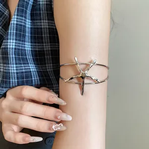 Detailed shot of a vintage silver metal starfish open arm cuff on a female model