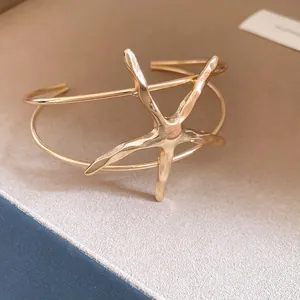 Detailed close-up of a metallic starfish open bangle with elegant gold finish