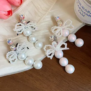 Exquisite pearl and rhinestone bow hair clips showing detailed craftsmanship and elegant design.