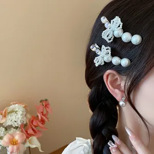 Close-up of elegant pearl bow hair clips and matching earrings on a model's braided hair