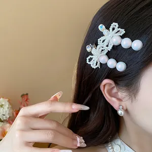 Elegant French style bow hair clip with pearls and rhinestones on a female model.
