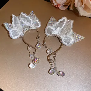 Close-up of delicate white lace butterfly ear cuffs with iridescent crystal pendants
