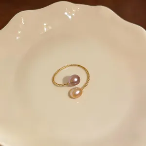 Vista dettagliata di un anello aperto a spirale placcato oro 14k con perle bicolore