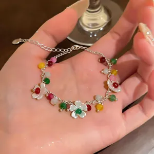 Vista dettagliata del bracciale con perline colorate e fiori bianchi sulla mano