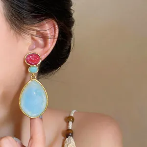 Primer plano de pendientes vintage de resina en forma de gota con detalles rojos y azules