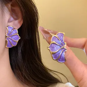 Elegant purple floral drop oil stud earrings with gold trim shown on model detail