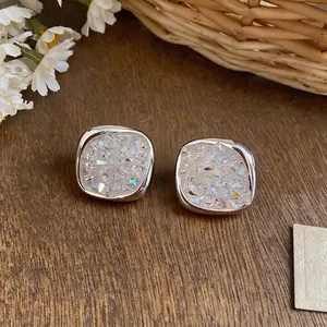 Elegant silver square zircon stud earrings with sparkling druzy texture on wooden background