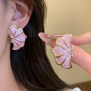 Close-up detail of vintage style pink flower stud earrings with shimmery gold border