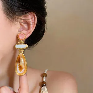 Primer plano de pendientes vintage de resina en forma de gota con elegante textura ámbar