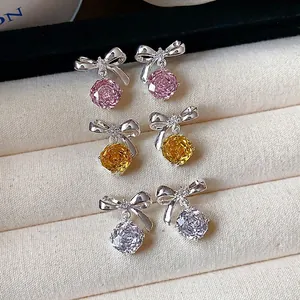 Orecchini a perno con fiocco e fiore in zircone, stili rosa, giallo e chiaro.