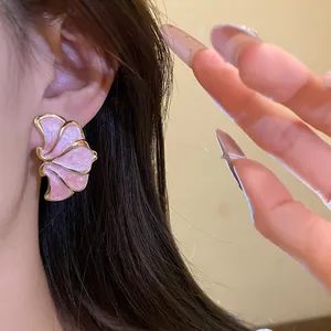 Macro view of vintage pink flower petal stud earrings with gold trim and shimmer