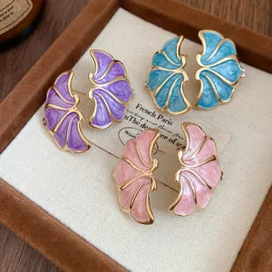 Detailed view of vintage enamel flower stud earrings in purple, blue, and pink colors
