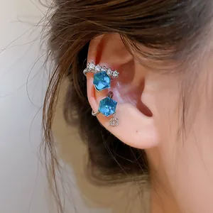 Detailed macro shot of elegant blue cubic zircon ear cuff worn on the ear bone area