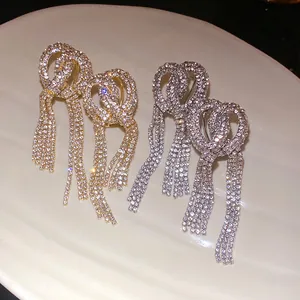 Macro view of luxurious gold and silver tassel earrings with full rhinestone bow knot design
