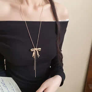 Detailansicht einer eleganten goldenen Halskette mit plissierter Schleife auf Schwarz